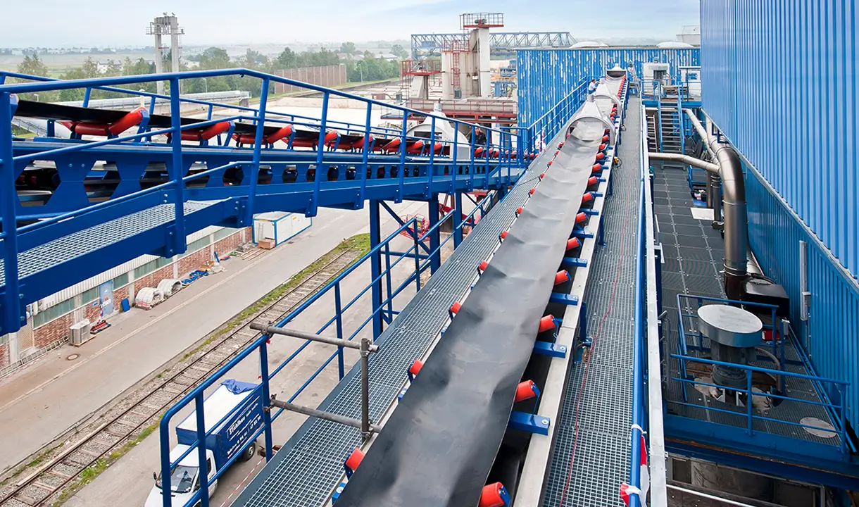Moderne Industrieanlage mit blauen Förderbändern und technischen Einrichtungen.
