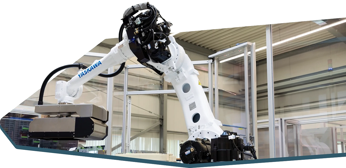 Ein industrieller Roboterarm der Marke Yaskawa in einer Fabrikumgebung. Der Arm ist weiß und mit verschiedenen mechanischen Komponenten ausgestattet. Im Hintergrund sind Metallrahmen und Fabrikbeleuchtung zu sehen.