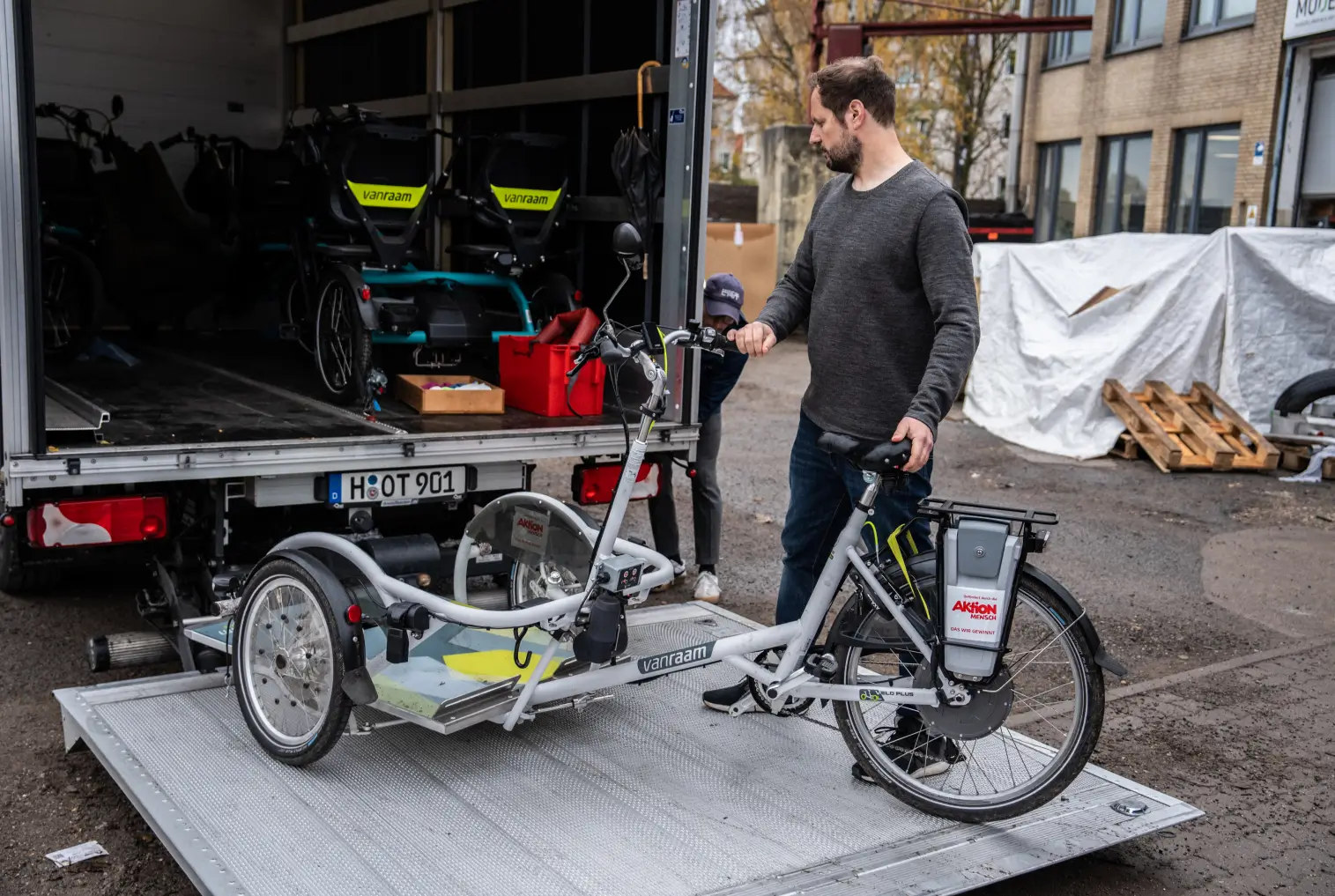 Eine Person steht neben einem Lastenfahrrad auf einer Laderampe.