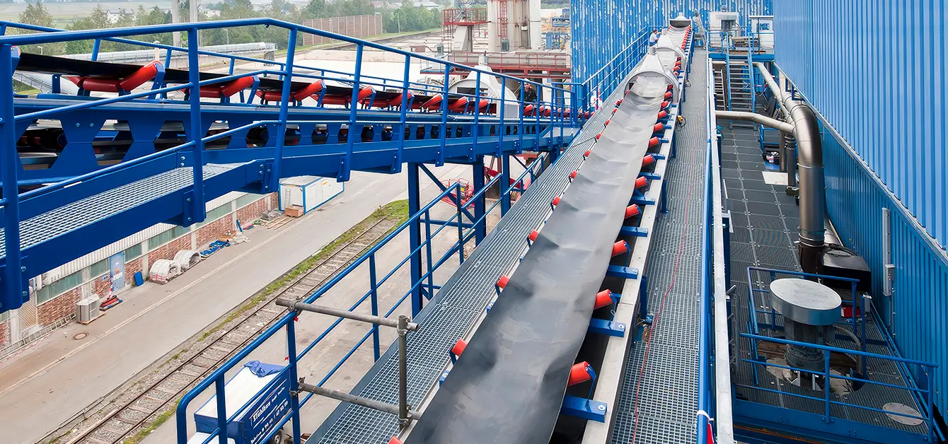 Moderne Industrieanlage mit blauen Förderbändern und technischen Einrichtungen.