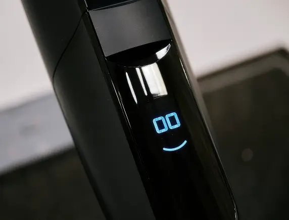 Nahaufnahme von zwei kabellosen Staubsaugern in Weiß und Schwarz vor einer weißen Kommode.