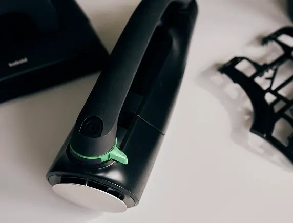 Technische Skizze eines Haushaltsgeräts auf Papier, umgeben von Materialproben.