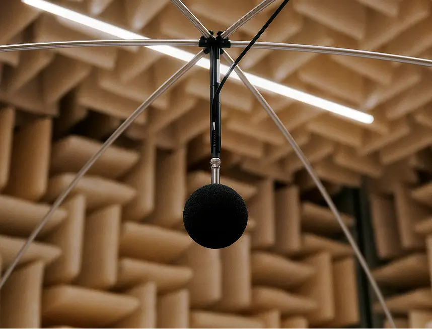 Mikrofon mit Windschutz hängt in schallabsorbierendem Raum an Metallgestänge